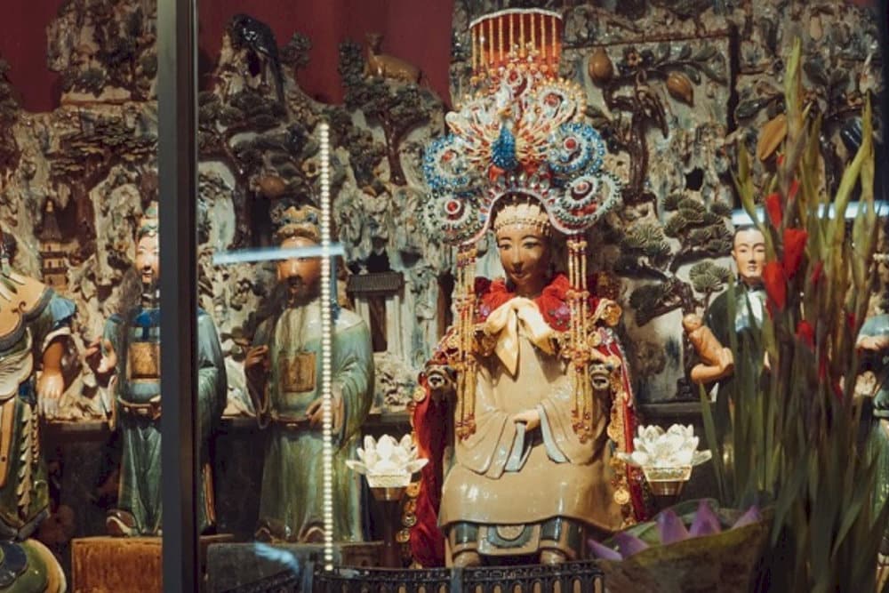 Devotees typically bring offerings such as fresh flowers, tropical fruits, and symbolic paper money to express their wishes
